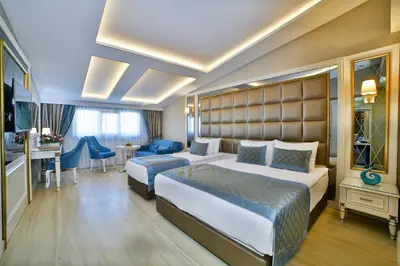 a hotel room with two beds and a desk at Büke Hotel Şişli in Istanbul