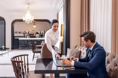 a man and a woman sitting at a table with a laptop at AKKA Lush Hotel Taksim in Istanbul