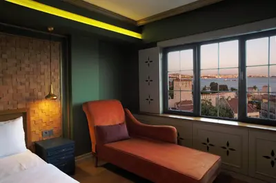 a bedroom with a bed and a chair and a window at Sublime Porte Hotel in Istanbul