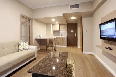 a living room with a couch and a flat screen tv at New Balturk Hotel Izmit in Kocaeli