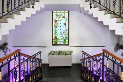 a hallway with stairs and a stained glass window at New Balturk Hotel Izmit in Kocaeli