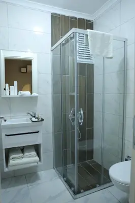 a bathroom with a shower with a sink and a toilet at Turkuaz Hotel in Gebze