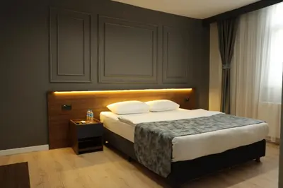 a bedroom with a large bed with a wooden headboard at Turkuaz Hotel in Gebze