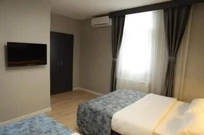 a hotel room with two beds and a television at Turkuaz Hotel in Gebze