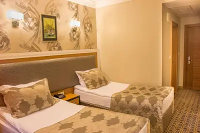 a hotel room with two beds and a chair at Grand Rosa Hotel in Istanbul