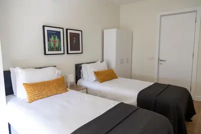 two beds in a room with white sheets and orange pillows at GALATA M84 in Istanbul