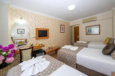 a hotel room with two beds and a desk at Grand Ons Hotel in Istanbul