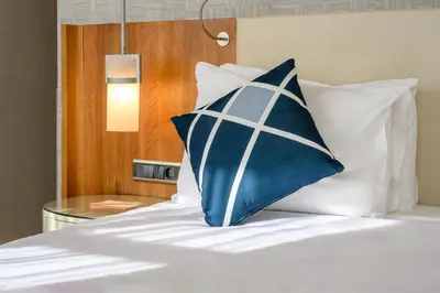 a bed with a blue and white pillow on it at Four Points Flex by Sheraton Istanbul Taksim Square in Istanbul