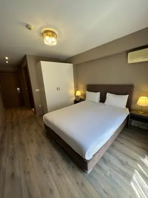 a bedroom with a large white bed with two pillows at Flower Palace Hotel in Istanbul