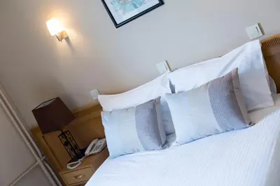 a bedroom with a bed with white pillows and a phone at Sidonya Hotel in Istanbul