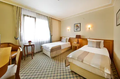 a hotel room with two beds and a window at Sidonya Hotel in Istanbul