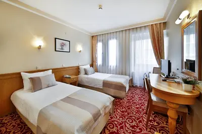 a hotel room with two beds and a desk at Sidonya Hotel in Istanbul