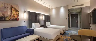 a hotel room with a bed and a blue chair at Hilton Istanbul Bakirkoy in Istanbul
