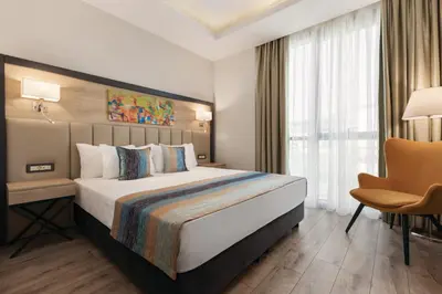 a hotel room with a large bed and a chair at Ramada Encore By Wyndham Istanbul Basin Express in Istanbul