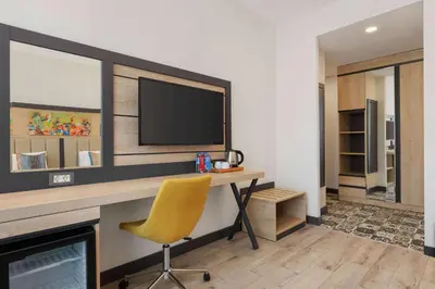 a room with a desk with a television and a chair at Ramada Encore By Wyndham Istanbul Basin Express in Istanbul