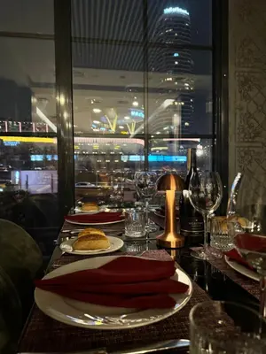 a table with a plate of food and wine glasses at Ramada Encore By Wyndham Istanbul Basin Express in Istanbul