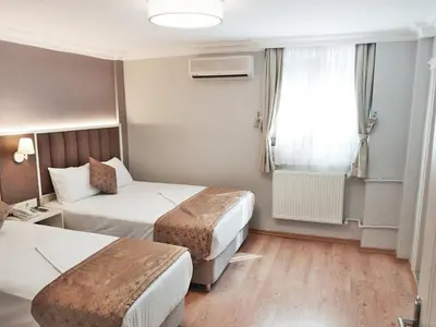 a hotel room with two beds and a window at Hotel Süreyya in Istanbul