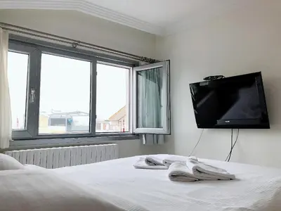 a bedroom with a bed with a flat screen tv on the wall at My Kent Hotel in Istanbul