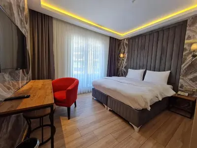a hotel room with a bed and a red chair at Air Boss Istanbul Airport and Fair Hotel in Istanbul
