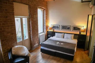 a bedroom with a bed and a brick wall at Taksim Galata Tower, Rooms Galata Historical Hotel in Istanbul
