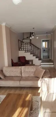 a living room with a couch and a staircase at Sawsana Villalari in Sapanca