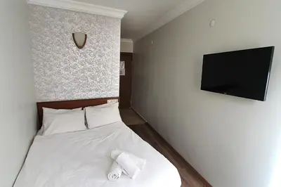 a bedroom with a bed and a flat screen tv at Lyon Hotel İstanbul in Istanbul