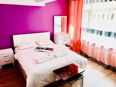 a bedroom with a white bed and a purple wall at Istanbul Harmony Hostel in Istanbul