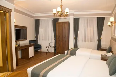 a hotel room with two beds and a television at Ahmet Efendi Konağı in Istanbul