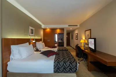 a hotel room with two beds and a desk at Crowne Plaza Istanbul Harbiye by IHG in Istanbul