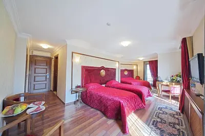 a bedroom with two beds with red covers at Antea Palace Hotel & Spa in Istanbul