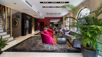 a lobby with pink chairs and plants in a building at Biz Cevahir Hotel Sultanahmet in Istanbul
