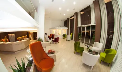 a lobby with green and white chairs and tables at Birbey Hotel in Istanbul