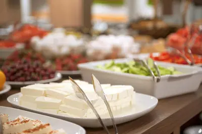 a table topped with plates of cheese and vegetables at Birbey Hotel in Istanbul