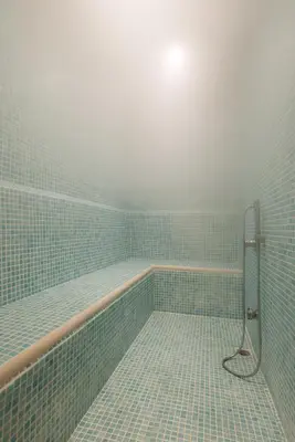 a blue tiled bathroom with a tub with a shower at Seminal Hotel Taksim in Istanbul
