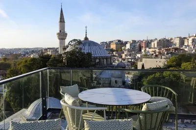 a table and chairs on a balcony with a view of a mosque at Dara Old City Hotel in Istanbul