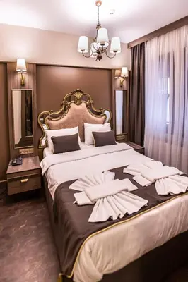 a bedroom with a large bed with towels on it at Dara Old City Hotel in Istanbul
