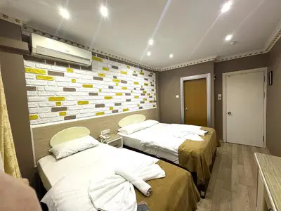 a room with two beds and a brick wall at Grand Oral Hotel in Istanbul