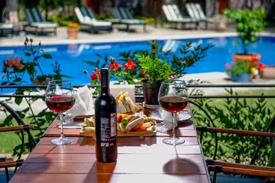 a table with two glasses of wine and a plate of food at Wineport Lodge Agva Riverside Hotel & Winery in Agva