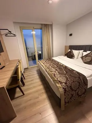 a bedroom with a bed and a desk and a window at Pendik Marine Hotel in Istanbul