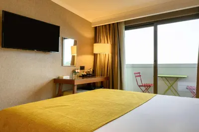 a hotel room with a bed and a flat screen tv at Ramada by Wyndham Istanbul Grand Bazaar in Istanbul