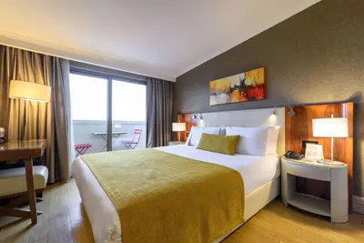 a hotel room with a large bed and a desk at Ramada by Wyndham Istanbul Grand Bazaar in Istanbul