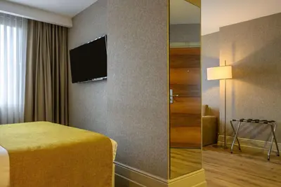 a hotel room with a bed and a television at Ramada by Wyndham Istanbul Grand Bazaar in Istanbul