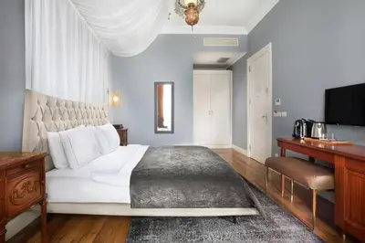 a bedroom with a large white bed and a desk at Lina Hotel Taksim Pera in Istanbul