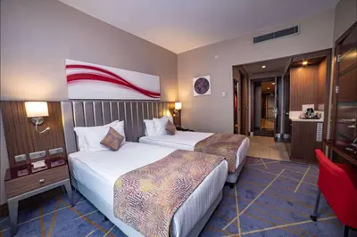 a hotel room with two beds and a bathroom at Ramada by Wyndham Istanbul Alibeykoy in Istanbul
