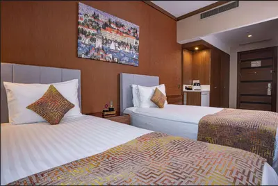 a hotel room with two beds and a painting on the wall at Ramada by Wyndham Istanbul Alibeykoy in Istanbul