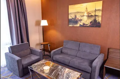 a living room with a couch and a table at Ramada by Wyndham Istanbul Alibeykoy in Istanbul