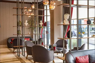 a waiting room with chairs and tables and windows at Ramada by Wyndham Istanbul Alibeykoy in Istanbul