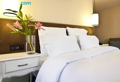 a bedroom with a white bed with a vase of flowers at Taximtown Hotel in Istanbul