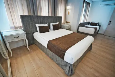 a bedroom with a large bed and a chair at Taximtown Hotel in Istanbul