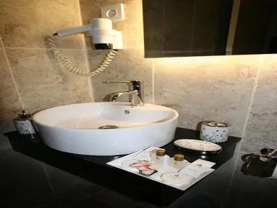 a white sink on a black counter in a bathroom at Maya Hotel in Istanbul